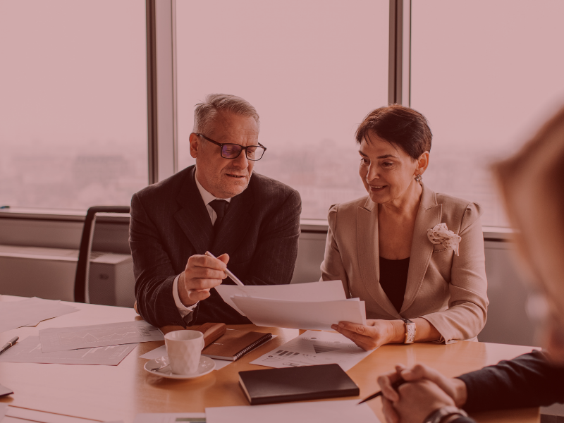 Insurance broker and care home manager reviewing a policy schedule together at a desk